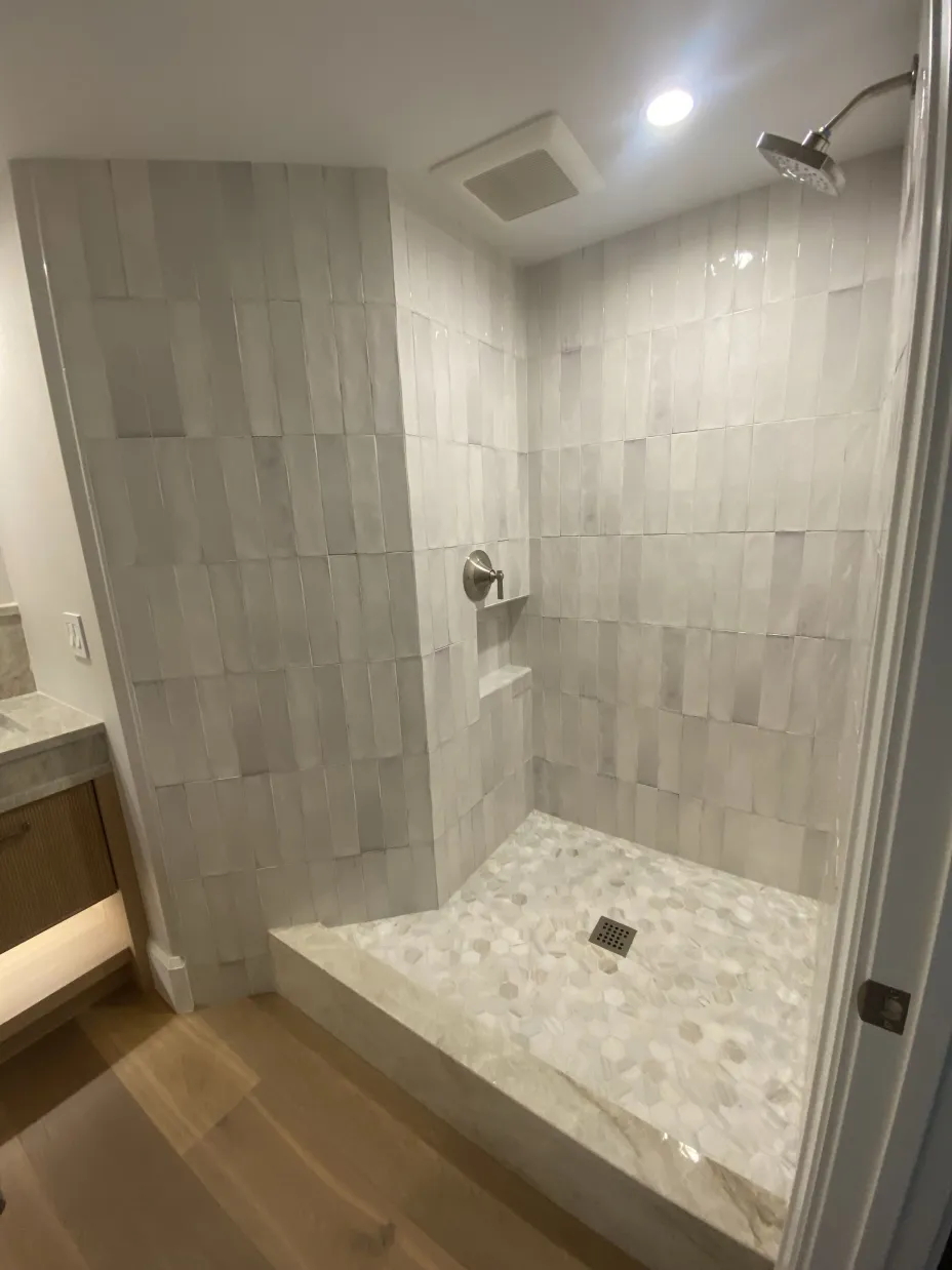 Custom shower with vertical zellige tile and hex marble floor